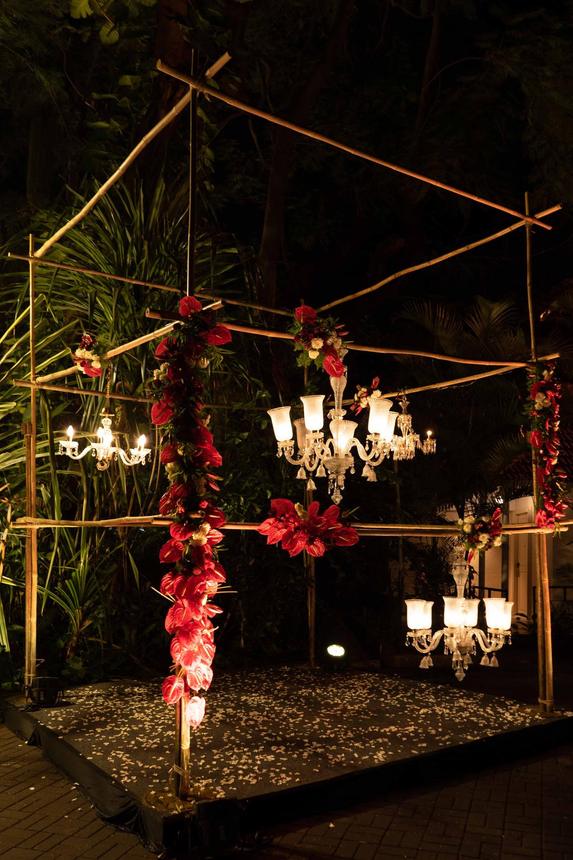 A chandelier hung over a candlelit garden setting