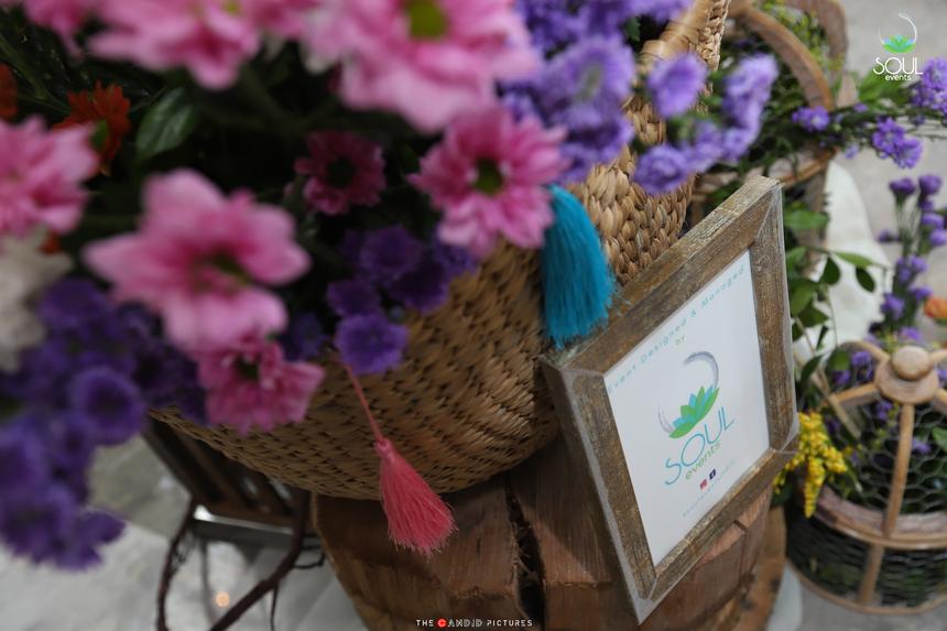 A cane basket of blooms beside a painted place card